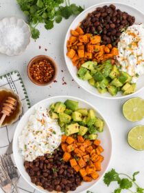 Top view of two vegetarian cottage cheese bowls with limes and cilantro in the background