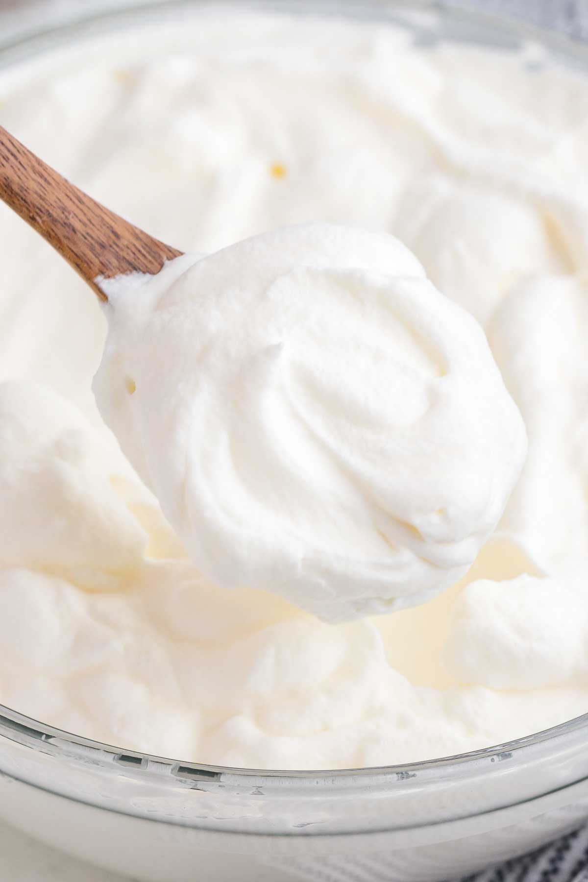 A spatula lifts out a scoop of freshly whipped cream