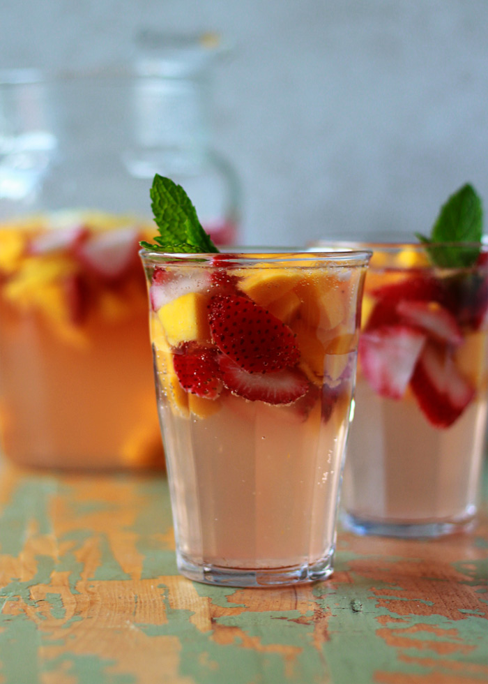 A glass of summer sangria on a green distressed wooden background. 